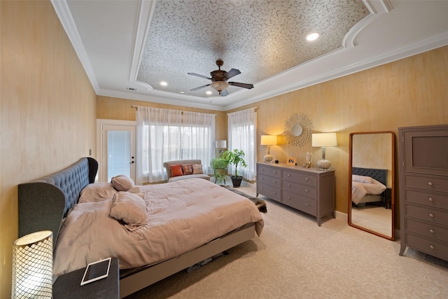 bedroom featuring visible vents, a ceiling fan, light colored carpet, ornamental molding, and a tray ceiling