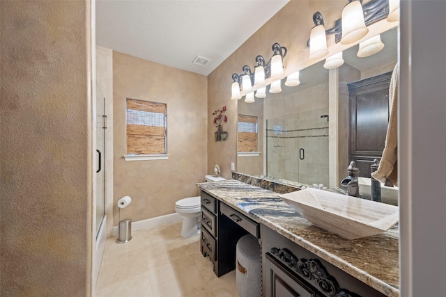 bathroom with toilet, visible vents, vanity, and a shower with door