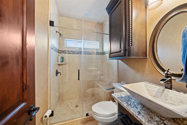 full bath with toilet, a shower stall, vanity, and a textured wall