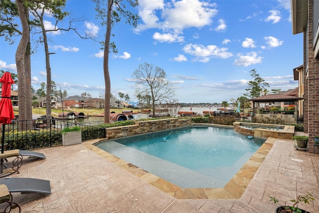 view of pool featuring a patio, fence, and a pool with connected hot tub