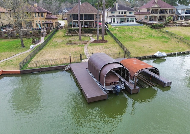 view of dock featuring a water view, a yard, and fence