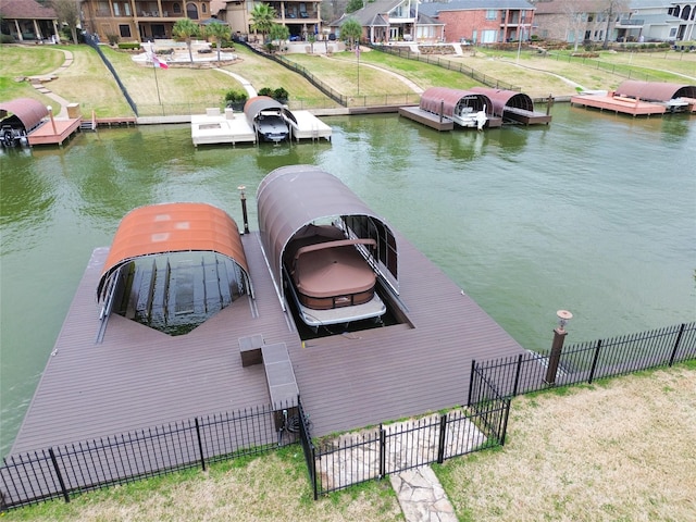 view of dock featuring a residential view, a water view, and fence