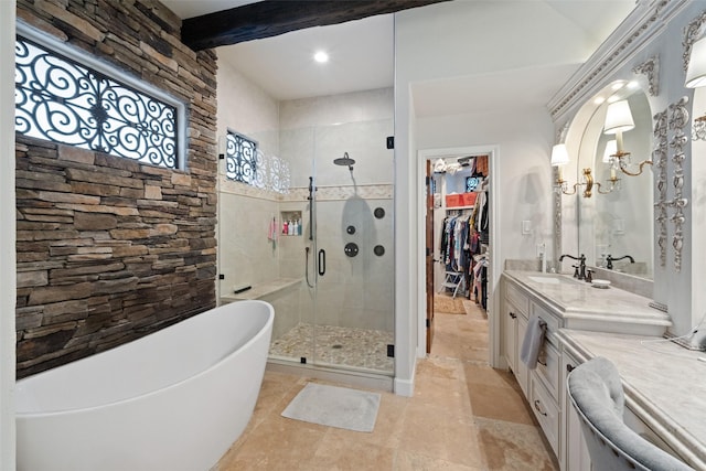 bathroom featuring a stall shower, beamed ceiling, a walk in closet, a freestanding bath, and vanity