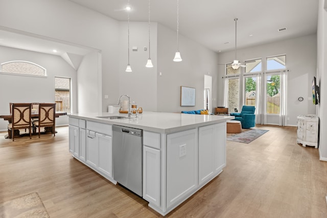 kitchen with light countertops, stainless steel dishwasher, light wood-type flooring, and a sink