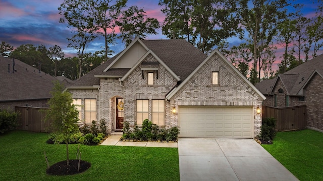 view of front of home with brick siding, fence, and a front lawn