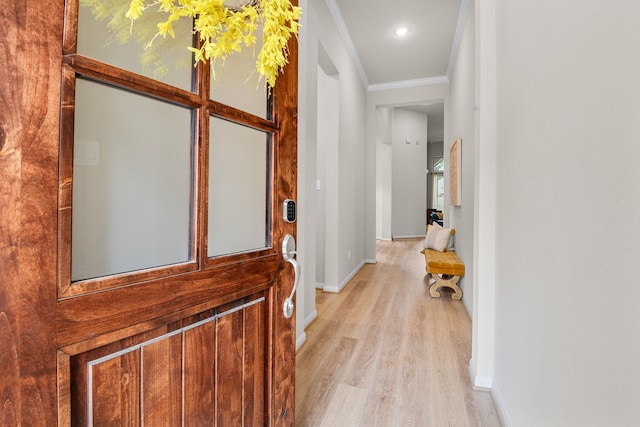 corridor featuring light wood-type flooring, baseboards, and crown molding