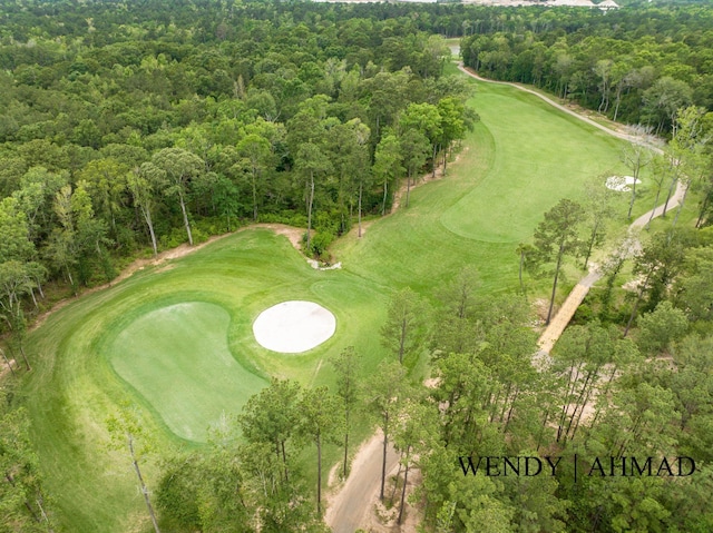 bird's eye view with view of golf course and a view of trees