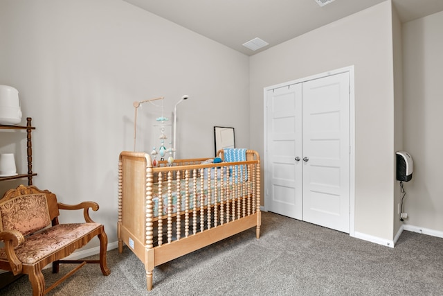 carpeted bedroom featuring baseboards and a closet