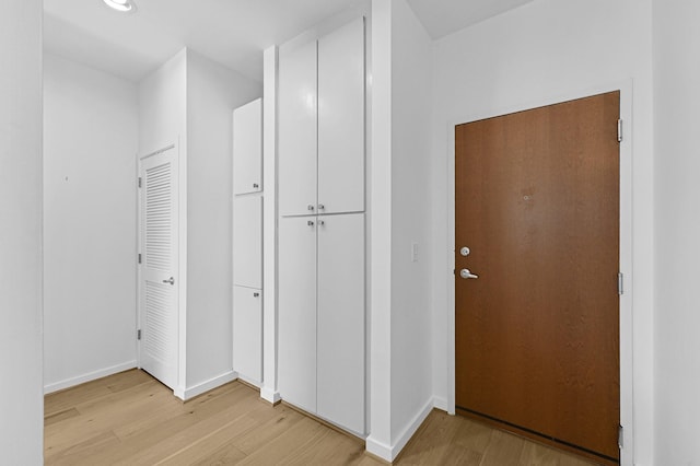 hallway with light wood-style flooring and baseboards