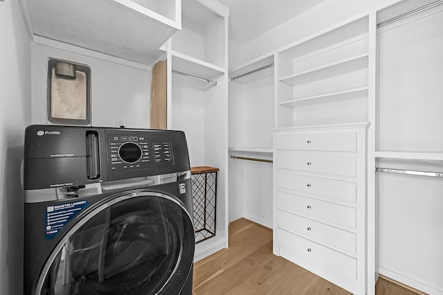 laundry area with laundry area, washer / clothes dryer, and wood finished floors