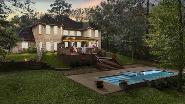 back of house featuring stairway, a yard, a deck, and a pool with connected hot tub