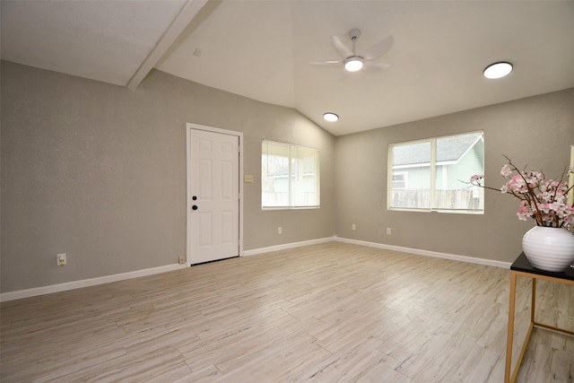 spare room featuring light wood-style floors, lofted ceiling, ceiling fan, and baseboards