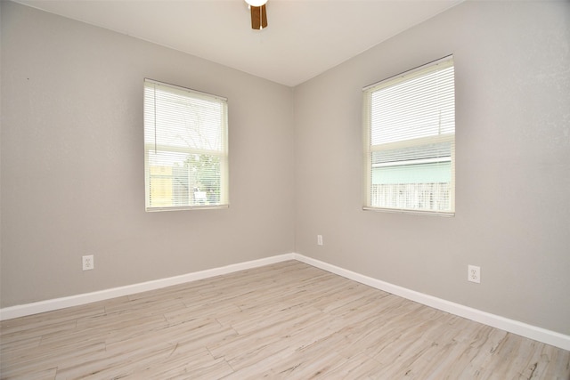 empty room featuring ceiling fan, baseboards, and wood finished floors