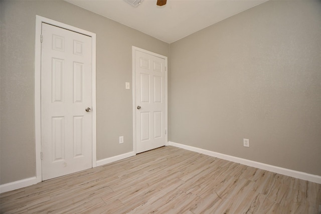 unfurnished bedroom with baseboards, ceiling fan, visible vents, and light wood-style floors