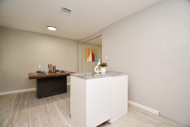 bar featuring light wood-style floors, visible vents, and baseboards