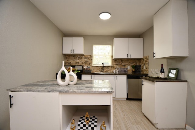 kitchen featuring light wood-type flooring, white cabinets, dishwasher, and decorative backsplash