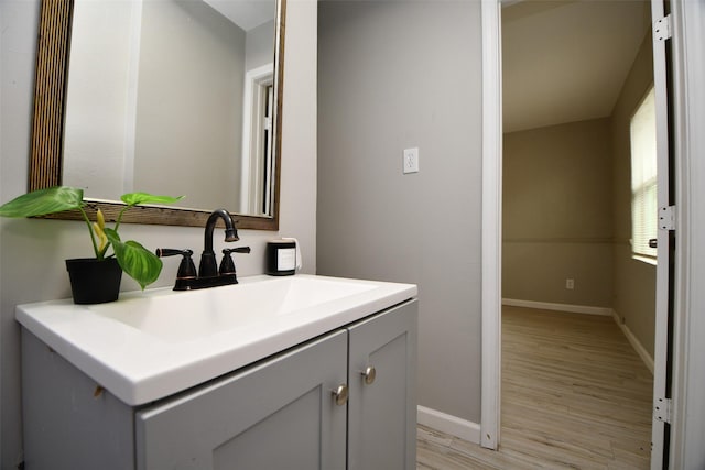 bathroom featuring wood finished floors, vanity, and baseboards