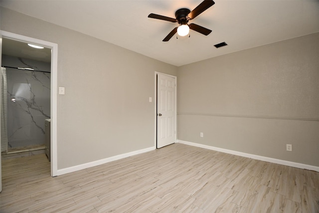 unfurnished bedroom featuring a spacious closet, a closet, light wood-type flooring, and baseboards