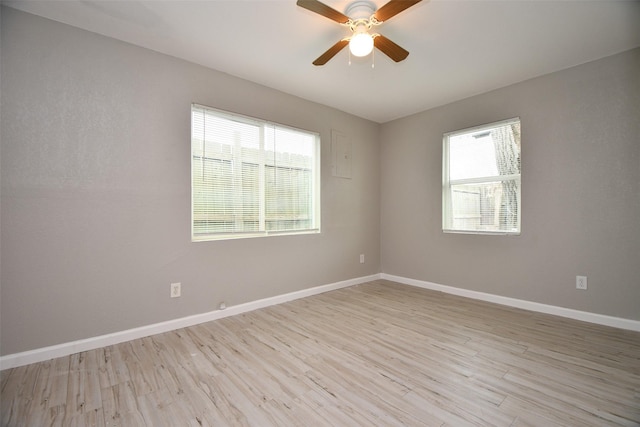 unfurnished room featuring ceiling fan, light wood-style flooring, and baseboards