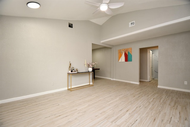 empty room with visible vents, a ceiling fan, vaulted ceiling, wood finished floors, and baseboards