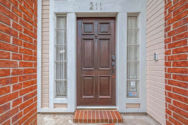 doorway to property with brick siding