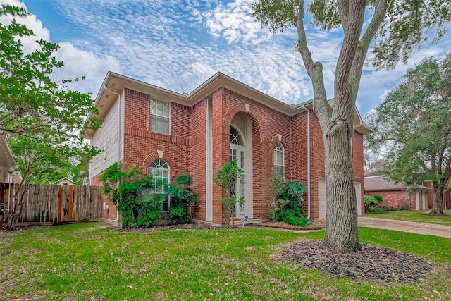 view of front facade with driveway, a garage, brick siding, fence, and a front yard