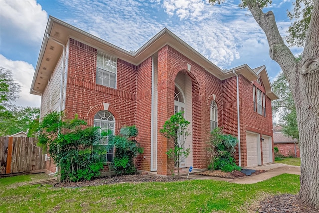 view of front facade featuring concrete driveway, an attached garage, fence, a front lawn, and brick siding