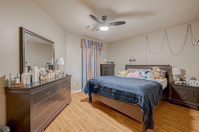 bedroom featuring light wood-style floors, ceiling fan, visible vents, and baseboards