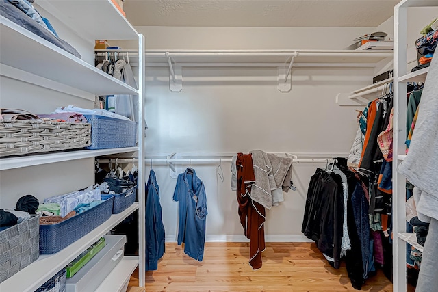 walk in closet with wood finished floors