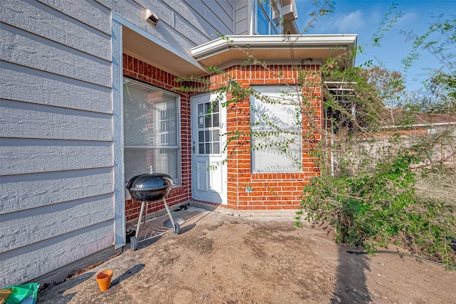 view of exterior entry featuring brick siding