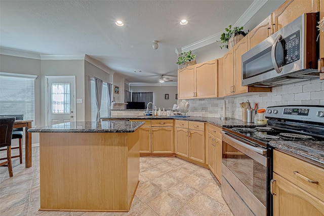 kitchen featuring tasteful backsplash, light brown cabinetry, appliances with stainless steel finishes, ornamental molding, and a kitchen island