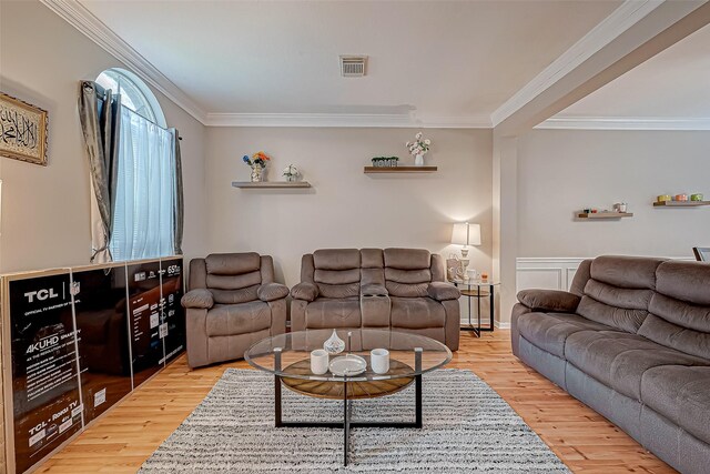 living room featuring ornamental molding, wood finished floors, and visible vents