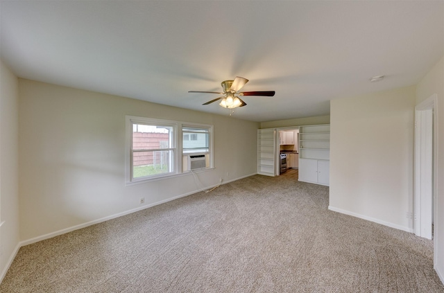 spare room featuring cooling unit, light colored carpet, ceiling fan, and baseboards