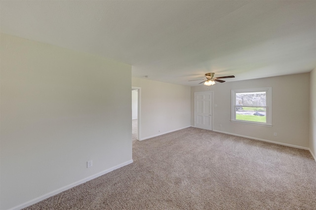 carpeted empty room featuring ceiling fan and baseboards