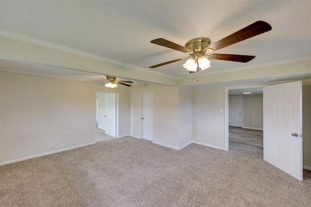 carpeted empty room featuring crown molding and baseboards