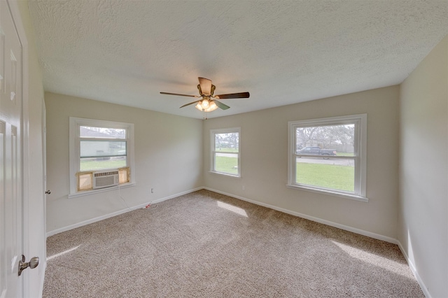 carpeted spare room featuring ceiling fan, cooling unit, and baseboards