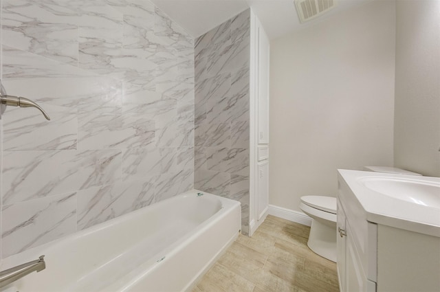 bathroom with visible vents, toilet, vanity, wood finished floors, and baseboards