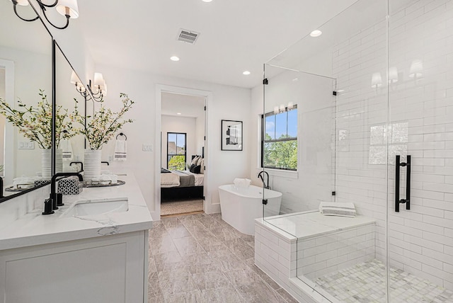 ensuite bathroom featuring a sink, visible vents, a freestanding bath, a shower stall, and double vanity