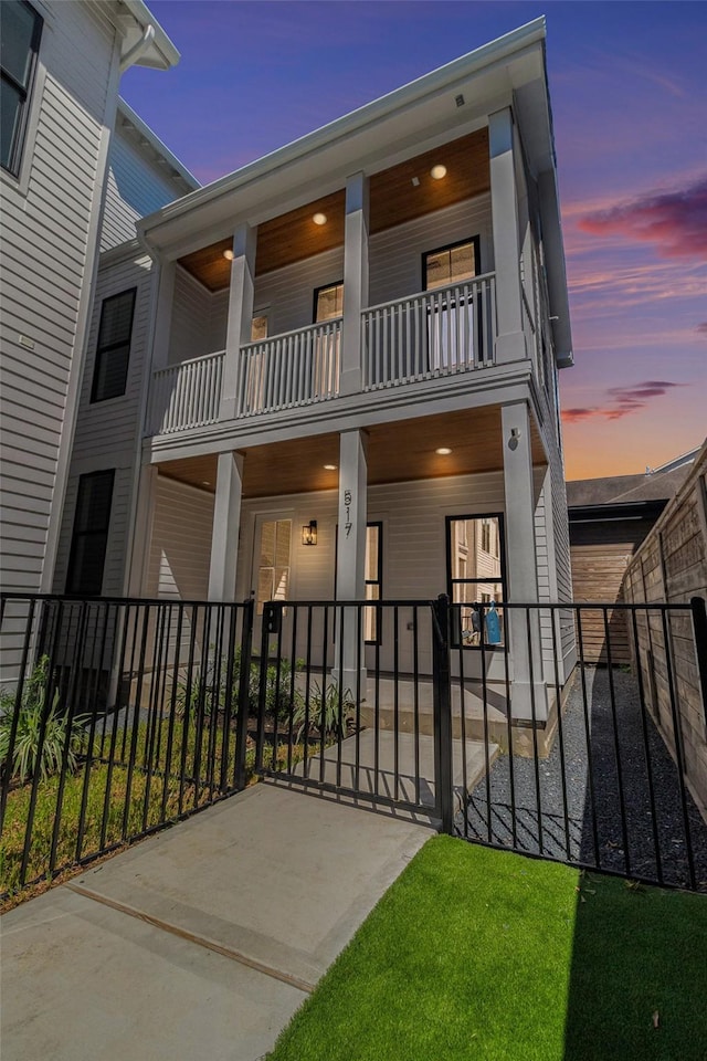 view of front of home featuring fence and a balcony