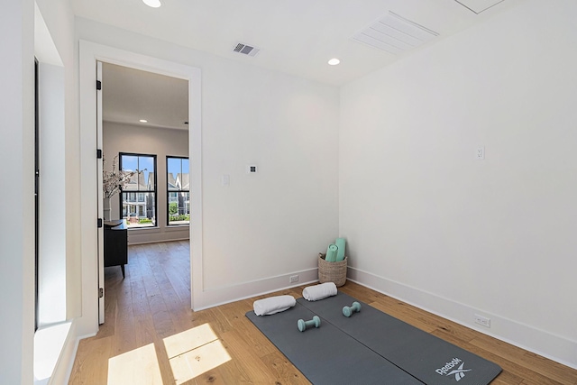 workout room featuring light wood-type flooring, visible vents, baseboards, and recessed lighting
