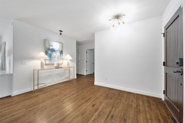 unfurnished living room featuring visible vents, baseboards, and wood finished floors