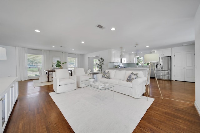 living area featuring dark wood finished floors, recessed lighting, visible vents, and a wealth of natural light