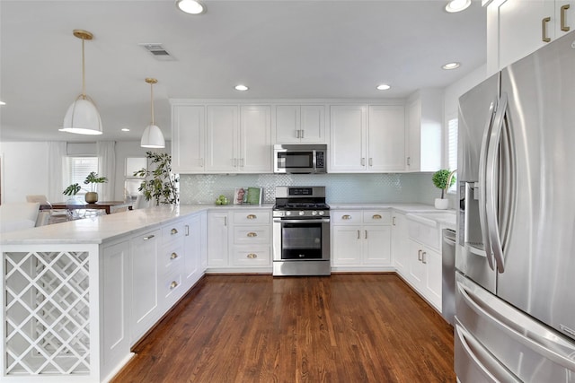 kitchen with dark wood-style floors, visible vents, a peninsula, stainless steel appliances, and white cabinetry