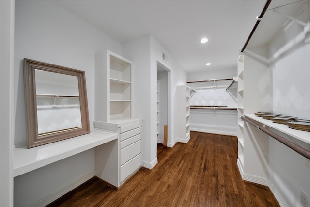 spacious closet featuring dark wood-style floors, visible vents, and built in study area