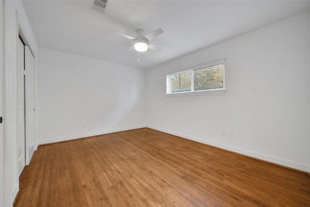 unfurnished bedroom featuring a ceiling fan, wood finished floors, visible vents, baseboards, and a closet