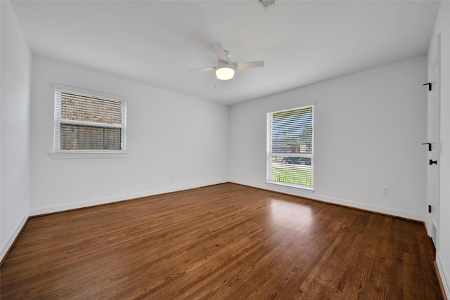 unfurnished room with dark wood-style floors, baseboards, and ceiling fan