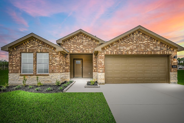 ranch-style house featuring concrete driveway, stone siding, an attached garage, a front lawn, and brick siding