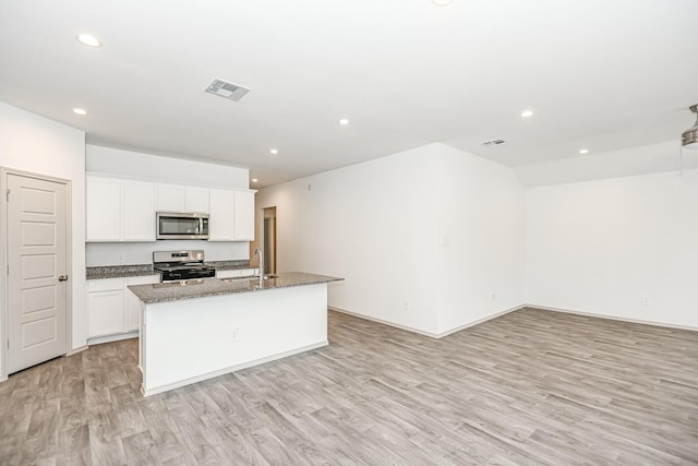 kitchen with a kitchen island with sink, light wood-style flooring, stainless steel appliances, a sink, and visible vents