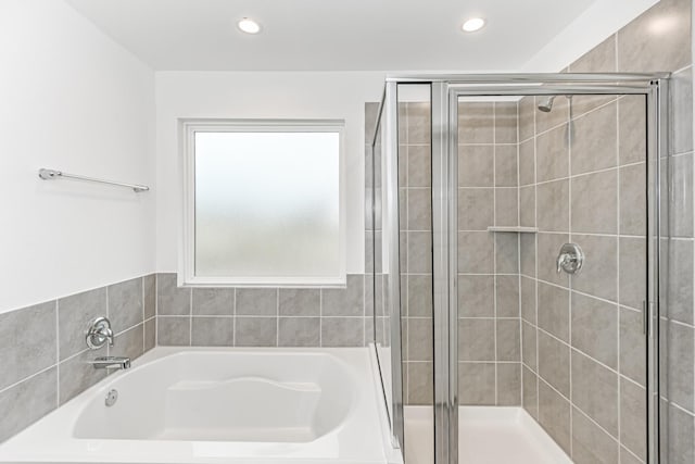 full bath featuring a stall shower, a bath, and recessed lighting