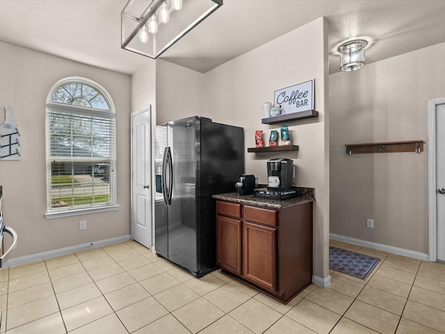 kitchen with baseboards, open shelves, stainless steel fridge with ice dispenser, and light tile patterned floors